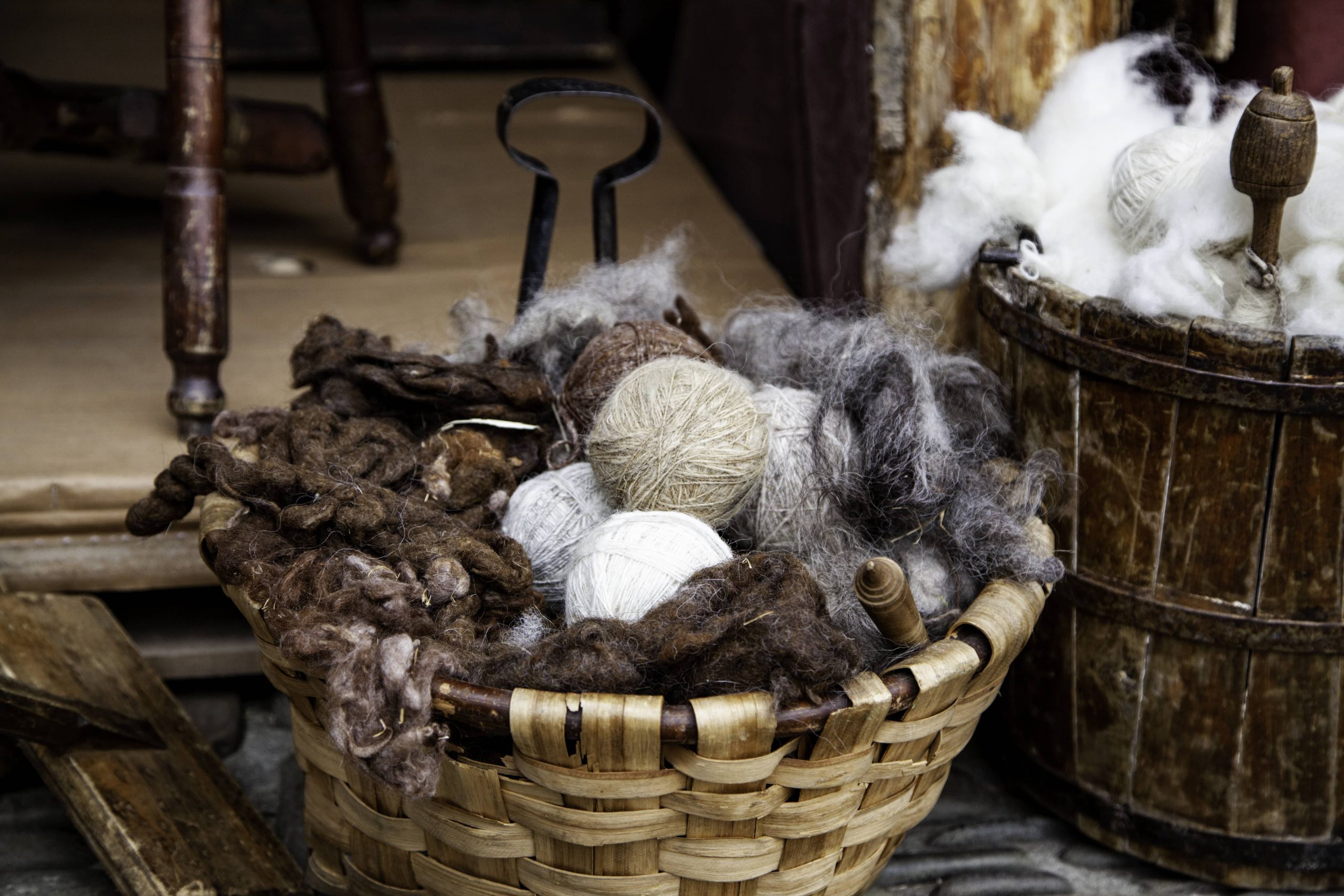 A basket of yarns in greys, whites, and browns.