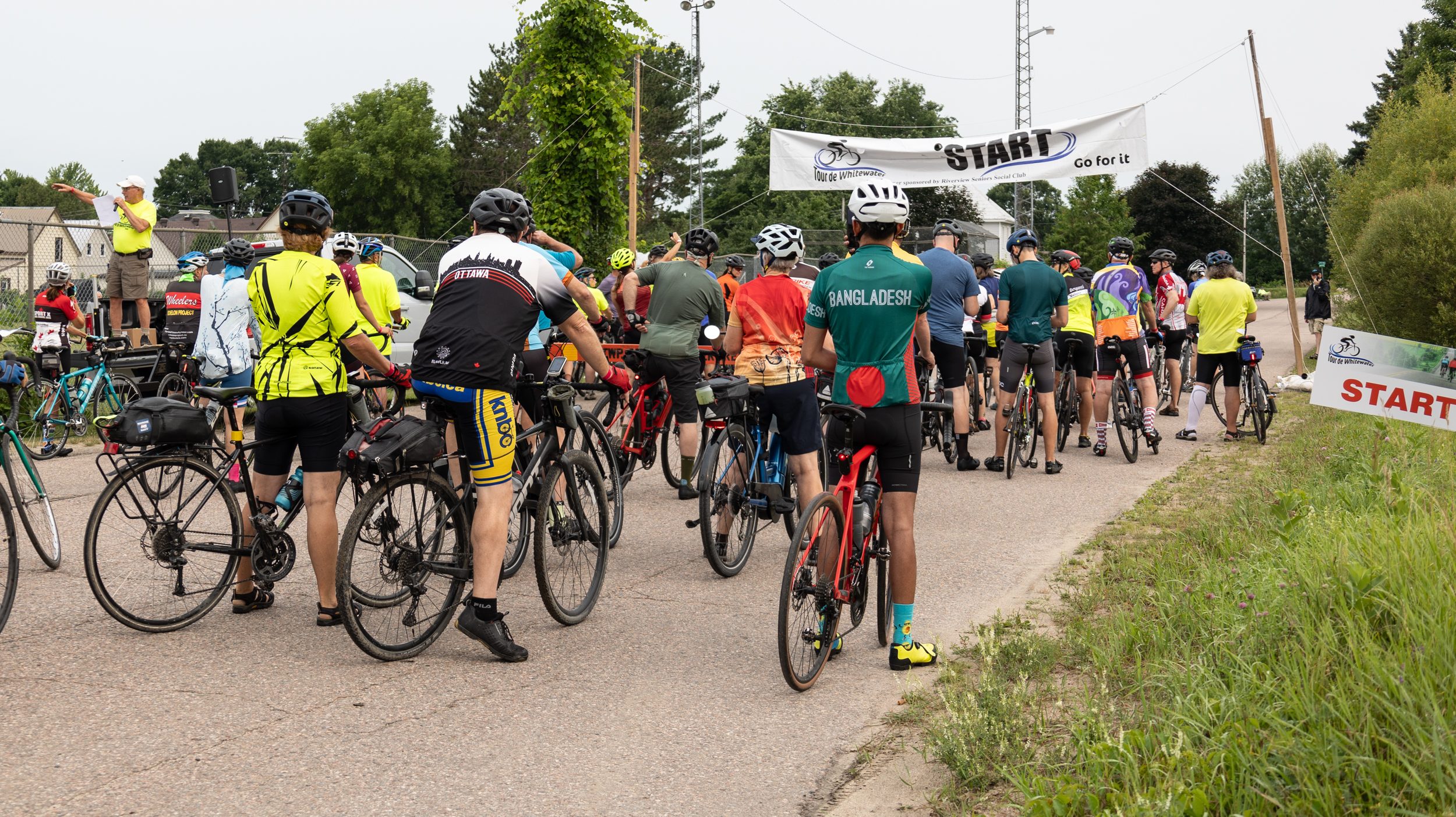 A group of cyclers at the starting line of a race, pictured from behind